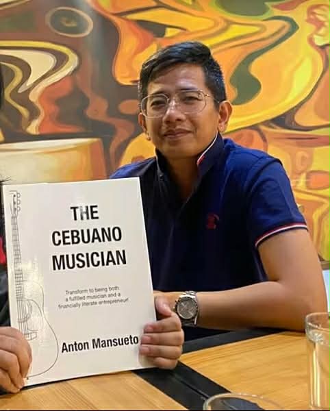 Anton Mansueto holding his book, The Cebuano Musician